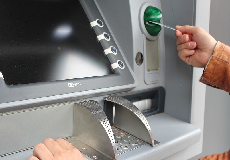 man puts card into atm