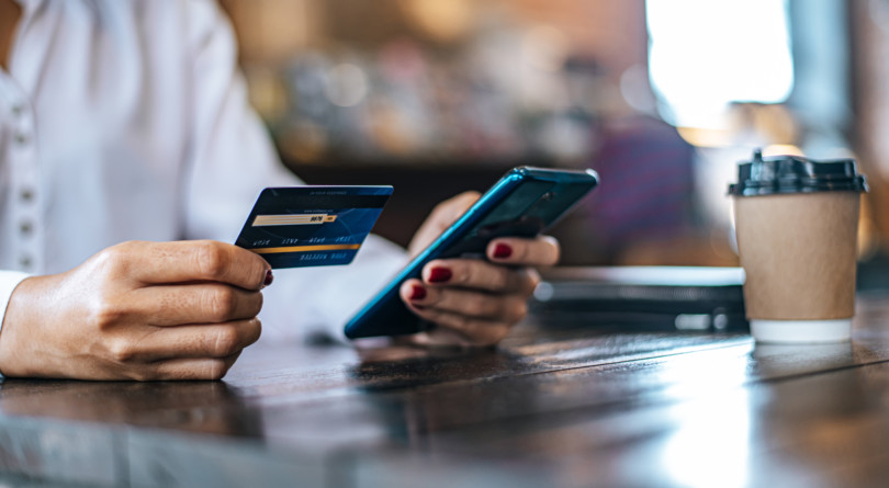 Pay for goods by credit card through a smartphone in a coffee shop. HSBC Exchange Rate Overview
