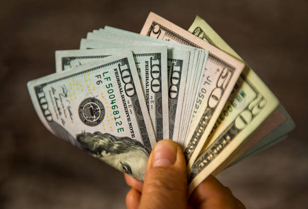 Unrecognizable mature man holding US Dollar bills. High angle view. Horizontal composition. Image taken with Nikon D800 and developed from RAW format. Compare Other National Bank of Canada Products