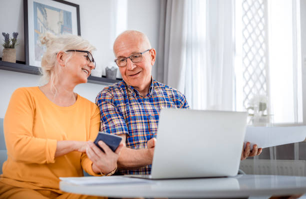 Senior couple checking bills using laptop at home National Bank of Canada Services