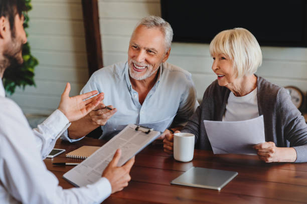 Happy aged couple consulting with insurance agent at home Desjardins Services