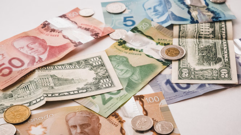 Multiple currencies, including U.S. dollars, Canadian dollars, and pesos, spread across a tabletop